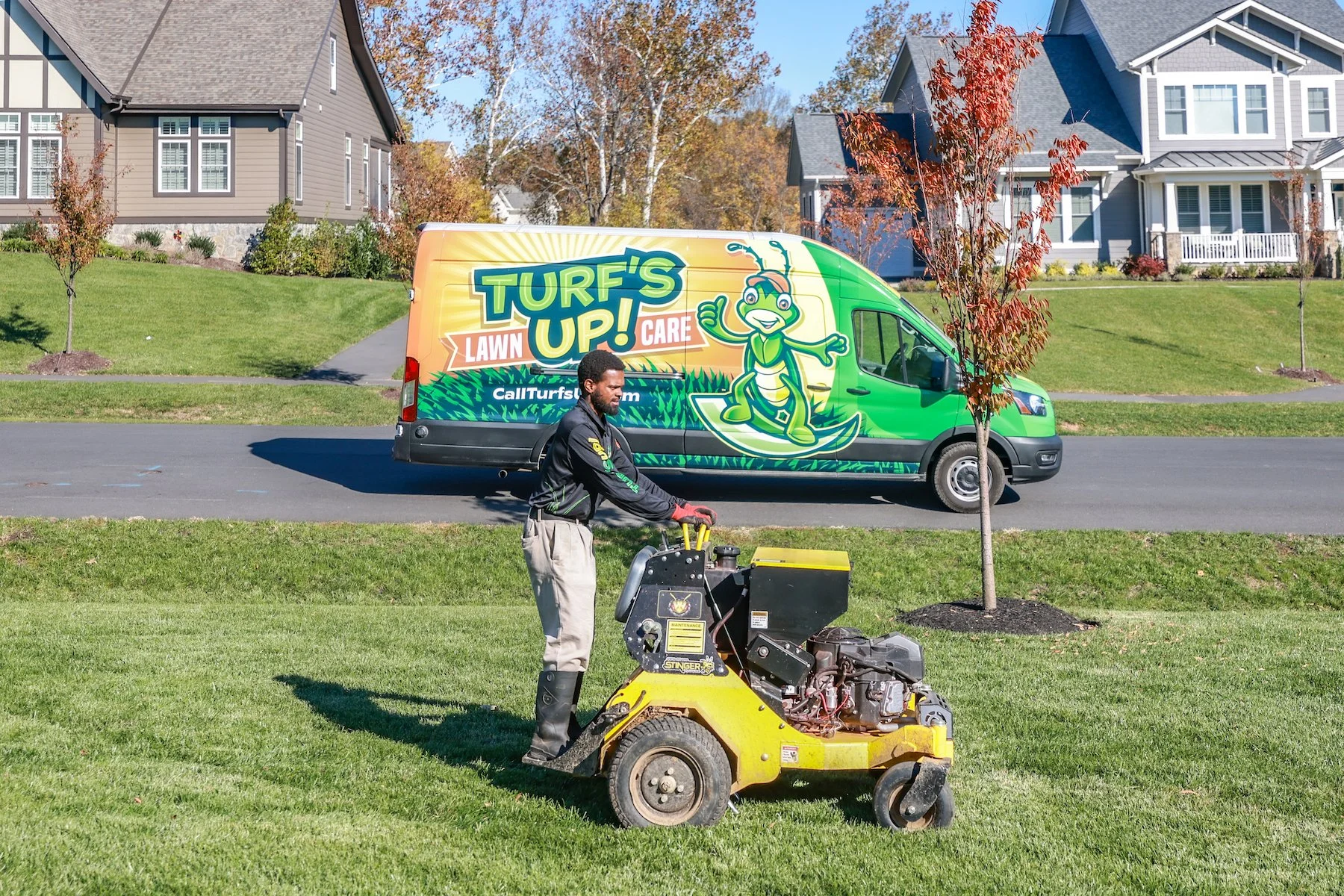 lawn care technician aerates lawn with ride on aerator