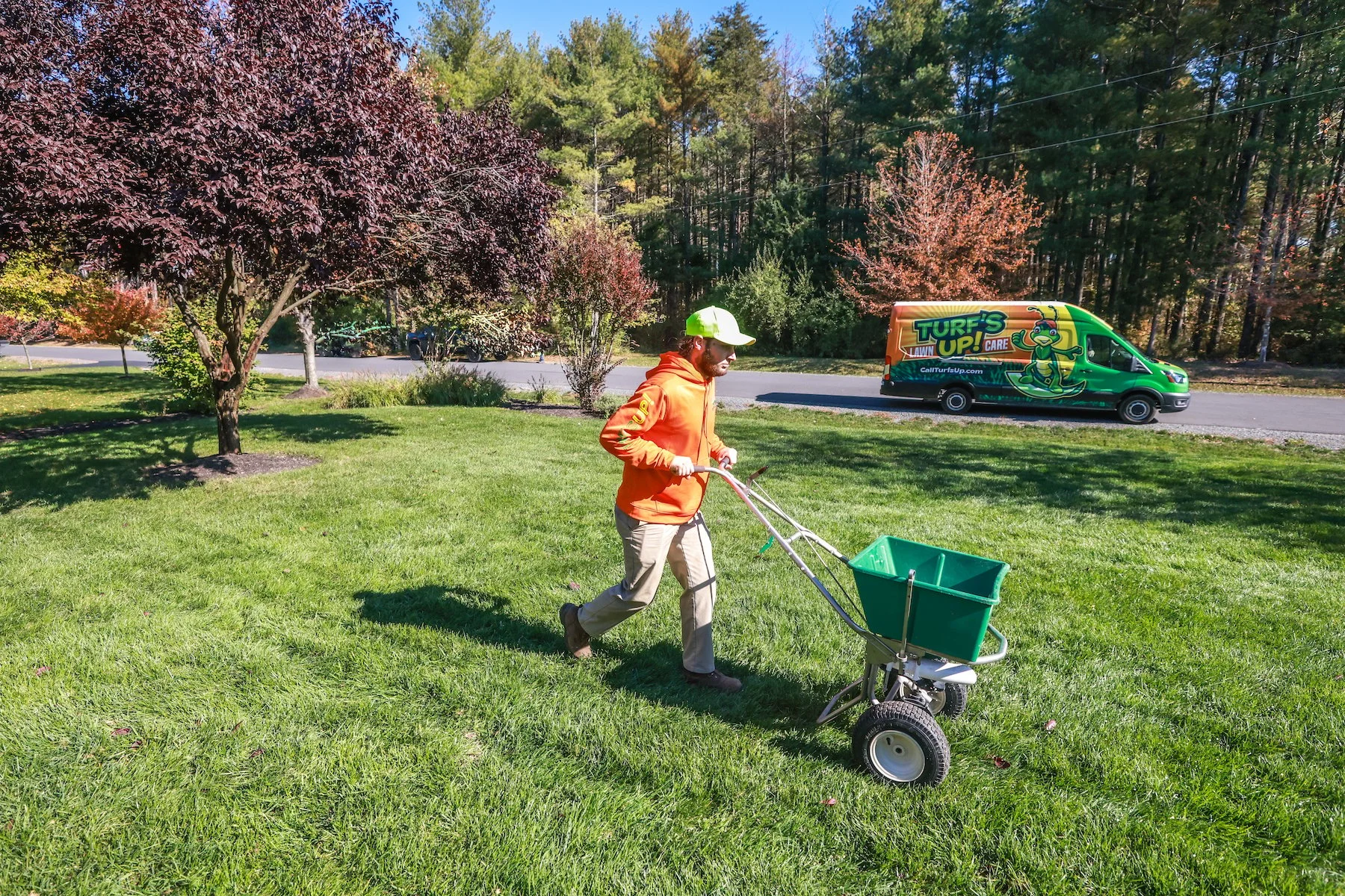 lawn care expert fertilizes grass in fall