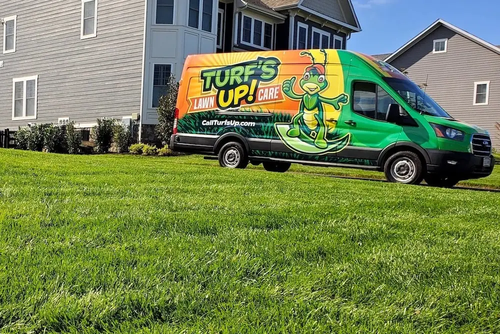 grass in front of home with lawn care truck parked out front