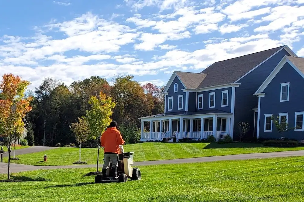 lawn care technician sprays lawn with liquid fertilizer