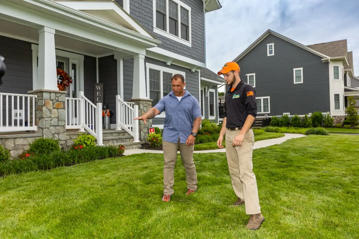 homeowner and customer inspect grass